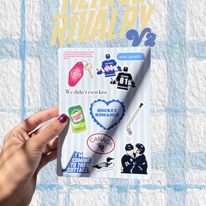 May include: A white sticker sheet featuring hockey-themed stickers, including a key tag, hockey players, a Canada Dry can, and the text "HOCKEY ROMANCE." The sheet is held by a hand against a blue and white background.
