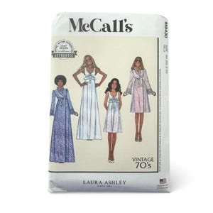 May include: A McCall's M8430 sewing pattern envelope featuring illustrations of four different dress styles. The text includes McCall's, M8430, Vintage 70's, and Laura Ashley. The designs show various lengths, sleeve styles, and waist ties for garments.