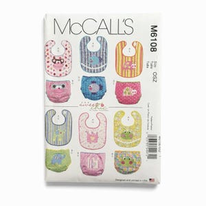 May include: McCall's M6108 sewing pattern envelope featuring illustrations of baby bibs and diaper covers. Designs include animal motifs like monkeys, fish, elephants, and frogs in various colors and patterns. Text includes brand name and size OSZ.
