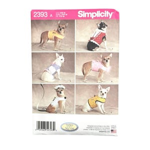 May include: A Simplicity sewing pattern envelope 2393 featuring six photographs of small dogs wearing various handmade vests and outfits. The package displays the brand name Simplicity, the pattern number 2393, and a barcode at the bottom.