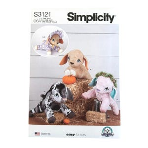 May include: A Simplicity S3121 sewing pattern envelope featuring illustrations of plush stuffed animals. The designs include a tan rabbit with a pumpkin, a black and white spotted animal, a pink animal with a green wreath, and one in a purple floral outfit.