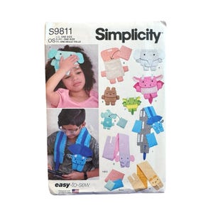 May include: Simplicity sewing pattern S9811 for stuffed animal accessories. The envelope features illustrations of various plush creatures including elephants and dragons, along with photos showing the finished items in use as head and neck wraps.