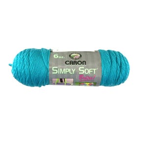 May include: A turquoise Caron Simply Soft yarn skein. The label reads "6 oz." and features the brand name and product line. The yarn is a vibrant teal color, tightly wound, and ready for crafting projects. The label also says "Brites!"