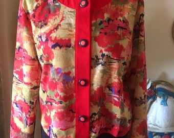 May include: A red and floral patterned jacket with a red button-up front and long sleeves. The jacket has a mandarin collar and a cropped hem.