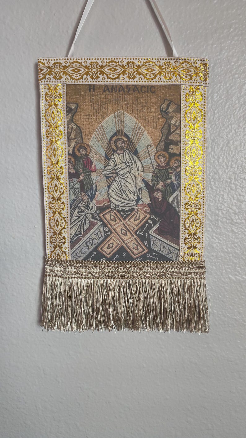 May include: A religious tapestry with a mosaic-style image of Jesus Christ surrounded by figures. The tapestry has gold trim and a fringe at the bottom. The text "H ANAFACIC" is at the top.