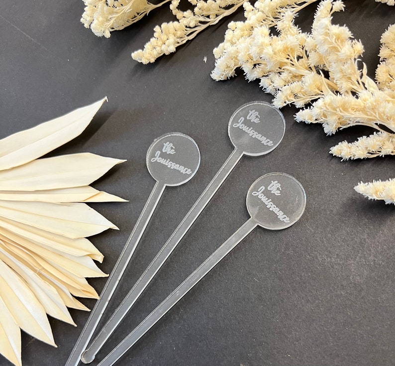 May include: Three clear acrylic cocktail stirrers with round, engraved tops that say "The Jouissance".