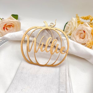 May include: Gold pumpkin-shaped napkin ring with the name "Willie" cut out.