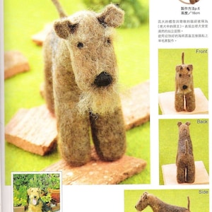 Pode incluir: Um cão Airedale Terrier marrom e branco feito de feltro. O cão está em pé sobre uma superfície marrom. O cão tem 16 cm de altura. A imagem mostra o cão de frente, de costas e de lado.