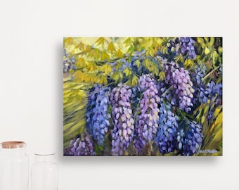 May include: An oil painting of wisteria flowers in shades of purple and blue, with yellow-green foliage. The artwork is displayed on a white wall above a wooden table, showcasing a vibrant floral scene.