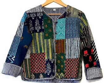 May include: A patchwork jacket with a variety of patterns and colors, including floral, striped, and geometric designs. The jacket is made of multiple fabric squares sewn together, creating a unique and colorful garment. It hangs on a wooden hanger.