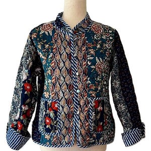 May include: A blue, green, and red quilted jacket with a floral pattern. The jacket has a mandarin collar, long sleeves, and two pockets. The fabric is a patchwork of different prints.
