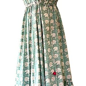 Puede incluir: Un vestido maxi sin mangas con escote en V y estampado floral. El vestido tiene una cintura ajustada y una falda de capas. El vestido est&aacute; hecho de una tela ligera y es perfecto para el clima c&aacute;lido.