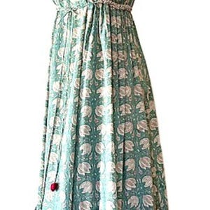 Puede incluir: Un vestido maxi sin mangas con escote en V y estampado floral. El vestido tiene un lazo en la cintura y una falda de capas.