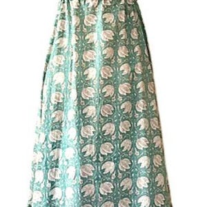 Puede incluir: Un vestido maxi sin mangas con fondo verde y estampado floral blanco. El vestido tiene un escote en V y un lazo en la cintura.