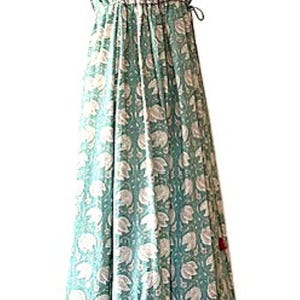 Puede incluir: Un vestido largo de maxi azul verdoso con estampado floral blanco. El vestido tiene una cintura fruncida y una falda de capas.