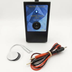 Puede incluir: Dispositivo electrónico negro con la inscripción "Fractal Solution" y "Zapper-Rapid 30kHz Clark Wave", con una luz azul y un botón de encendido. Incluye cables rojos y negros y una almohadilla de electrodo redonda.