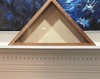 May include: Triangular wooden display case with a clear front. The case has a light wood interior and a darker wood frame. The shape is ideal for displaying a flag or other memorabilia. The case is resting on a white surface.
