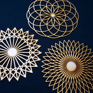 May include: Three wooden geometric wall decor pieces with intricate laser cut designs. The designs are circular and feature a variety of geometric shapes and patterns.