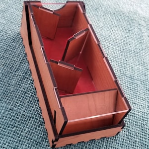 May include: A wooden box with a clear plastic lid and multiple compartments. The box is stained a light brown color and has black edges. The compartments are lined with red felt.