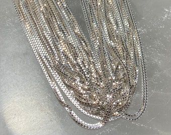 Puede incluir: Un collar de cadena de plata. La cadena está hecha de pequeños eslabones cuadrados y es muy delicada.