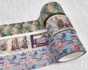May include: Four rolls of washi tape with different designs. The top roll has a green and pink floral pattern with a blue bird. The second roll has a vintage postcard design with a cityscape. The third roll has a blue and pink floral pattern with pagodas. The fourth roll has a blue and pink floral pattern with pagodas.