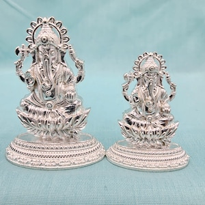 Pu&ograve; includere: Due statue argentate di Ganesh. Le statue presentano disegni dettagliati e poggiano su basi a forma di fiore di loto. La statua pi&ugrave; grande &egrave; alta circa 10 cm, mentre quella pi&ugrave; piccola &egrave; alta circa 7,6 cm.