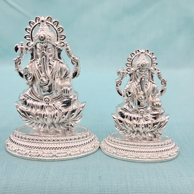 Pu&ograve; includere: Due statue argentate di Ganesh. Le statue presentano disegni dettagliati e poggiano su basi a forma di fiore di loto. La statua pi&ugrave; grande &egrave; alta circa 10 cm, mentre quella pi&ugrave; piccola &egrave; alta circa 7,6 cm.