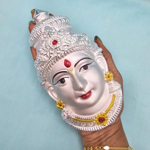 Rostro de Ammavari en plata pura. Rostro de Lakshmi Devi en plata auténtica para decoración de pooja. Rostro pintado con esmalte de imitación y anillos traseros para atar.