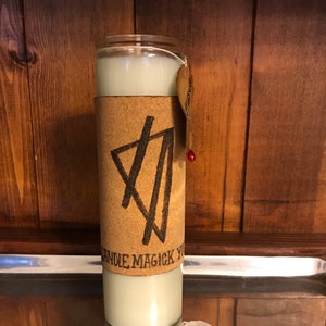 May include: A white candle with a cork and paper label that says "Candle Magick You". The label has a black and white graphic design on it. The candle is sitting on a silver tray.