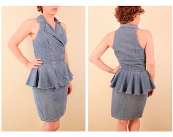 May include: A denim dress with a peplum skirt and a button-up bodice. The dress is sleeveless and has a halter neckline.
