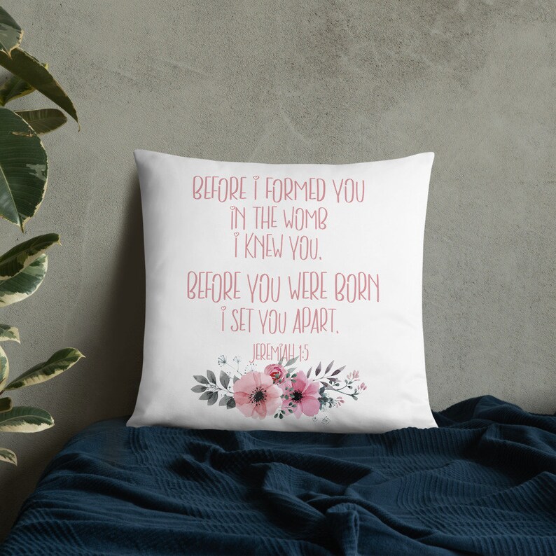 May include: White throw pillow with a floral design and the text "BEFORE I FORMED YOU IN THE WOMB I KNEW YOU. BEFORE YOU WERE BORN I SET YOU APART. JEREMIAH 1:5"