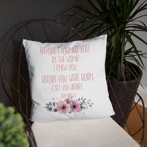 May include: White throw pillow with a floral design and the text "BEFORE I FORMED YOU IN THE WOMB I KNEW YOU. BEFORE YOU WERE BORN I SET YOU APART. JEREMIAH 1:5"