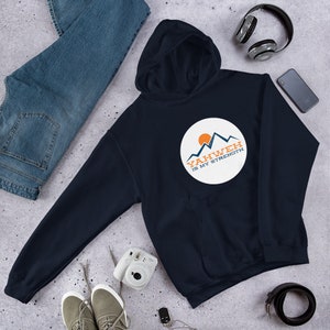 May include: A navy blue hoodie with a white circle graphic featuring a mountain range and a sun. The text "Yahweh is my strength" is written in orange and blue on the graphic.