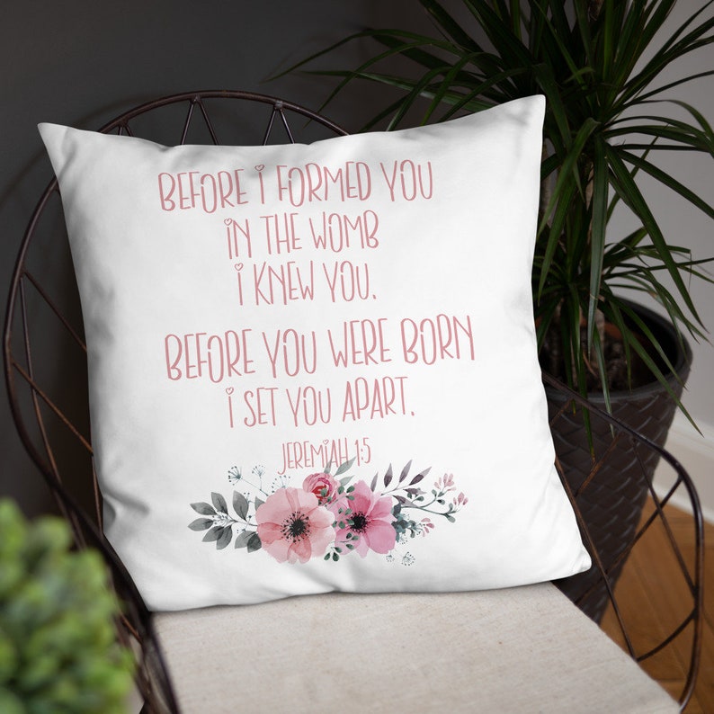 May include: White throw pillow with a pink floral design and the text "BEFORE I FORMED YOU IN THE WOMB I KNEW YOU. BEFORE YOU WERE BORN I SET YOU APART. JEREMIAH 1:5"