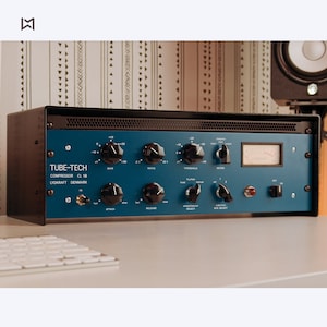 May include: A blue audio compressor unit with the text "TUBE-TECH COMPRESSOR CL 1B LYDKRAFT DENMARK" on the front. The unit has knobs for gain, ratio, threshold, attack, release, and side select.