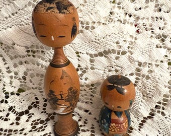 Conjunto vintage de 2 muñecas Kokeshi japonesas, figuras de madera maciza pintadas a mano. Una más alta con escena de paisaje y otra más pequeña en miniatura con cabeza oscilante.