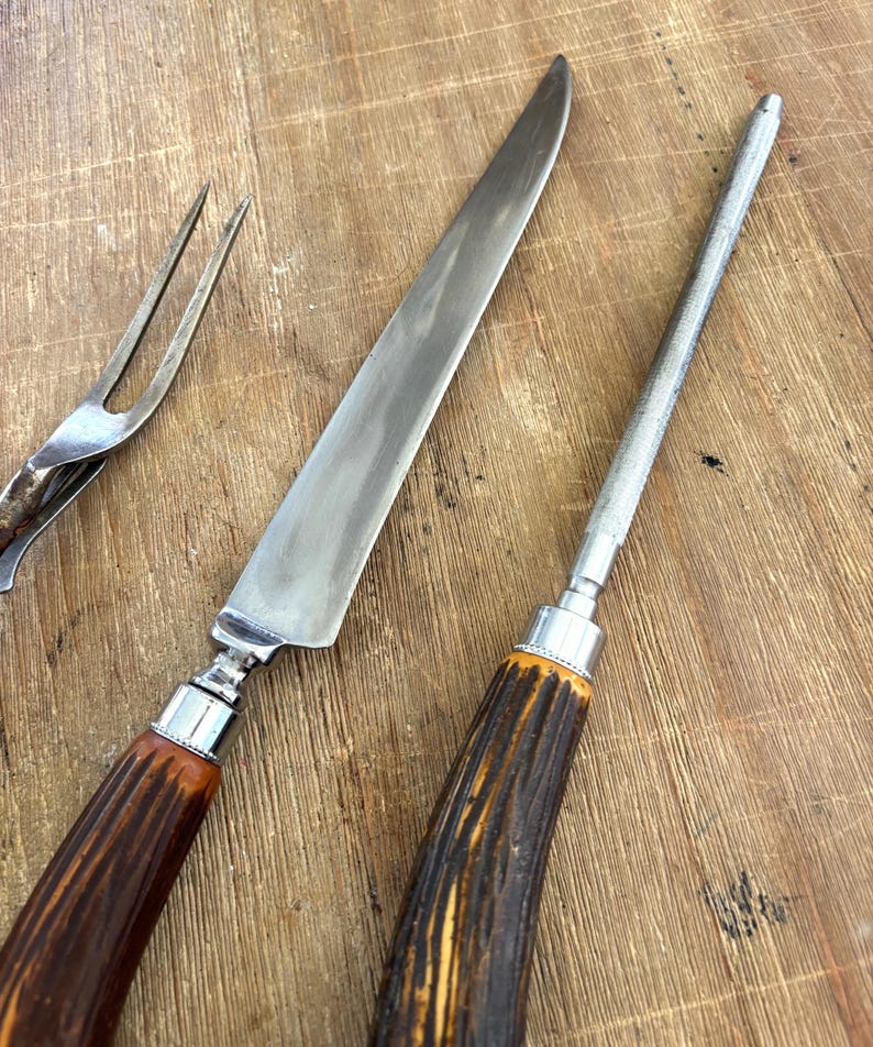Puede incluir: Un juego de trinchar vintage que incluye un cuchillo largo para trinchar, una chaira y un tenedor para trinchar. Los mangos son de material marr&oacute;n oscuro con un dise&ntilde;o texturizado y el juego tiene detalles met&aacute;licos plateados.