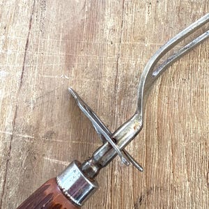 Puede incluir: Tenedor para trinchar vintage con cabeza de acero inoxidable y mango marr&oacute;n texturizado. El tenedor tiene dos p&uacute;as y un protector de metal. El mango es de material marr&oacute;n oscuro. Dise&ntilde;ado para trinchar carne.