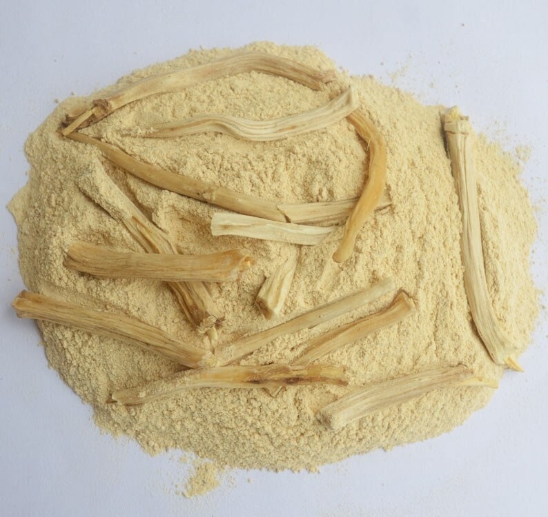 May include: A pile of light brown powder with several long, thin, light brown sticks on top. The powder and sticks are likely a type of herbal supplement.