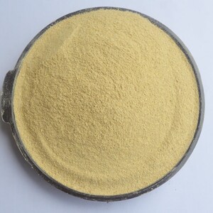 May include: A close-up view of a bowl filled with a light beige powder. The powder is finely ground and has a uniform texture.