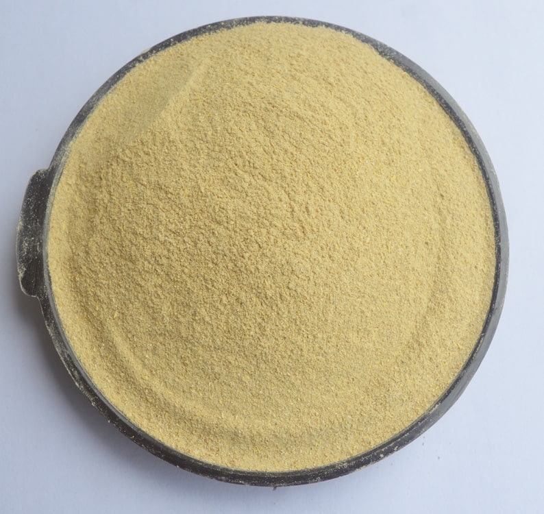 May include: A close-up view of a bowl filled with a light beige powder. The powder is finely ground and has a uniform texture.