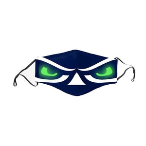 May include: Navy blue face mask with a stylized eye design. The mask features glowing green eyes and white accents, creating a striking contrast against the dark blue fabric. Adjustable ear loops are visible.