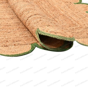 May include: A round jute rug with a scalloped edge and a green trim. The rug is made of natural fibers and has a rustic look.