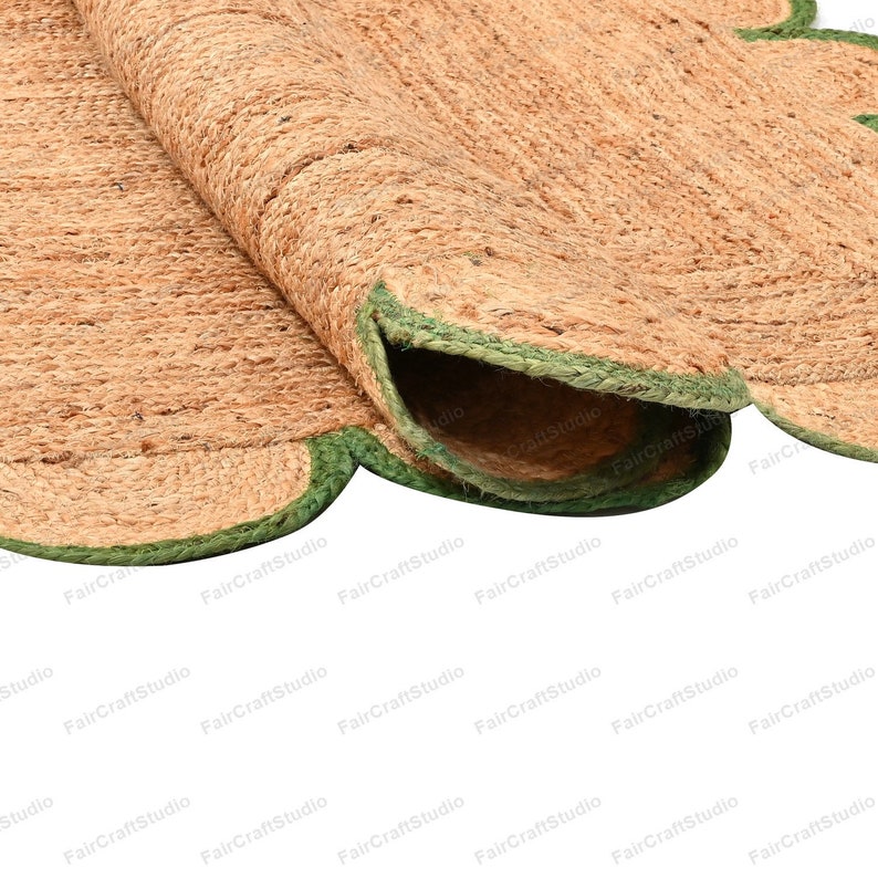 May include: A round jute rug with a scalloped edge and a green trim. The rug is made of natural fibers and has a rustic look.