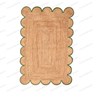 May include: A natural fiber rug with a scalloped border in a green color. The rug has a woven texture and a rectangular shape.