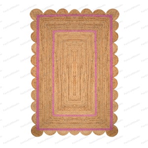 May include: A rectangular jute rug with a pink border and a scalloped edge. The rug has a woven texture and a natural brown color.