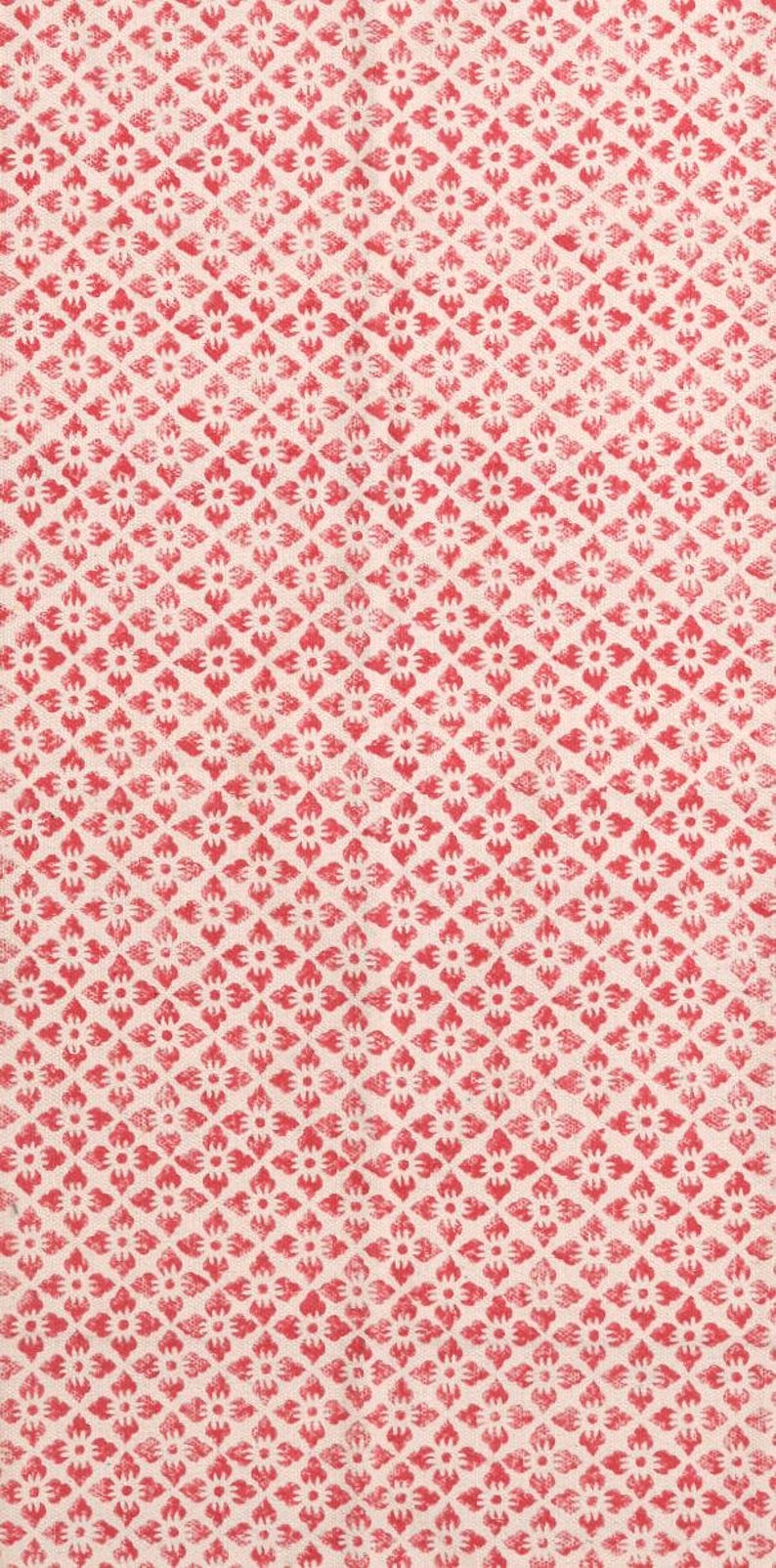 May include: A close-up of a fabric featuring a repeating pattern of red floral motifs on a cream background. The design is arranged in a diamond grid, creating a textured appearance. Suitable for textiles or home decor.