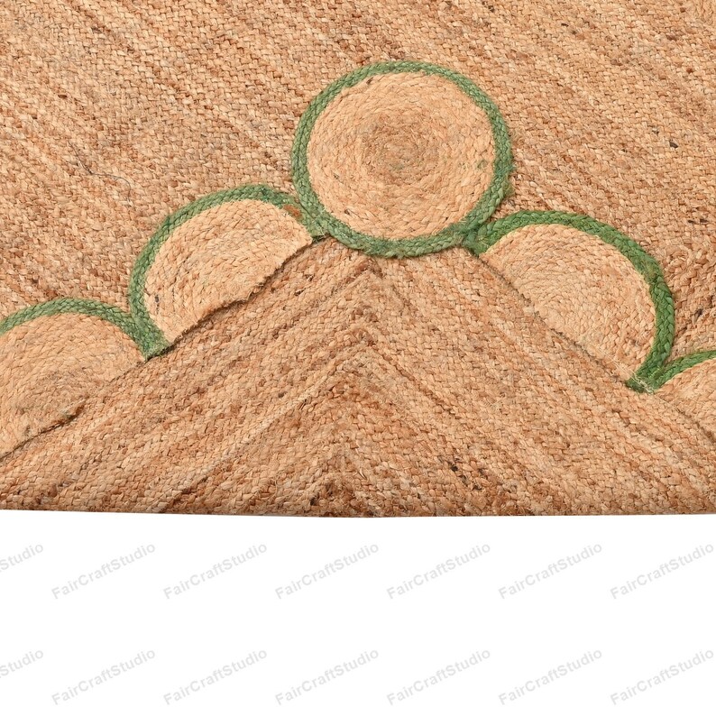 May include: A natural fiber rug with a woven texture and a green trim. The rug has a geometric pattern with rounded edges.