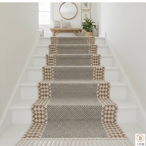 May include: A patterned stair runner in beige and grey, featuring a central checkered design and diamond edges. The runner, with a fringed bottom, is laid on white stairs. The overall design creates a neutral, textured look.