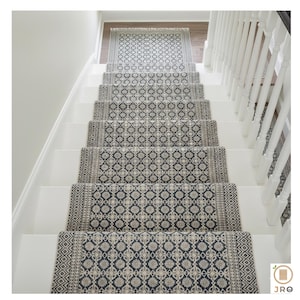 Peut inclure: Escalier avec contremarches blanches et un tapis de course à motifs. Le tapis de course présente un motif géométrique répétitif dans les tons de gris et de crème. L'escalier a une rampe blanche sur le côté droit.